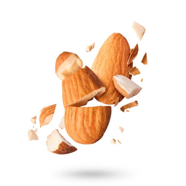 Flying in air fresh raw whole and cut almonds  isolated on white background. Concept of Almonds is torn to pieces close-up. High resolution image